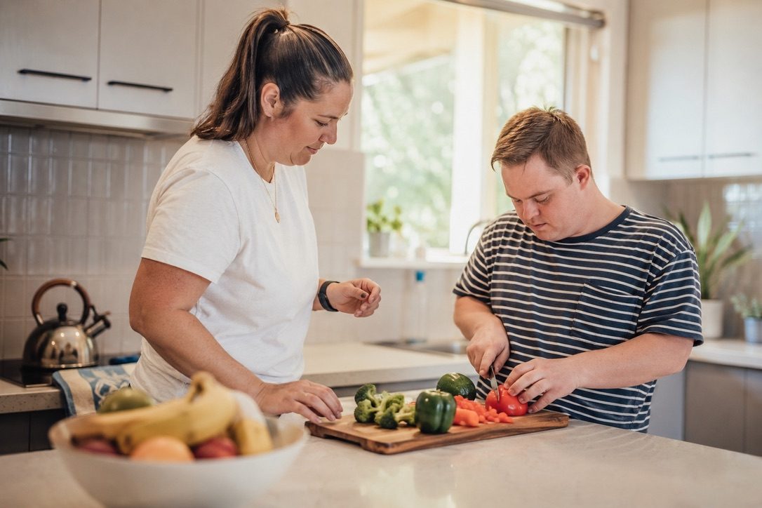 NDIS daily living support worker helping a participant prepare a meal in a Melbourne East home kitchen
