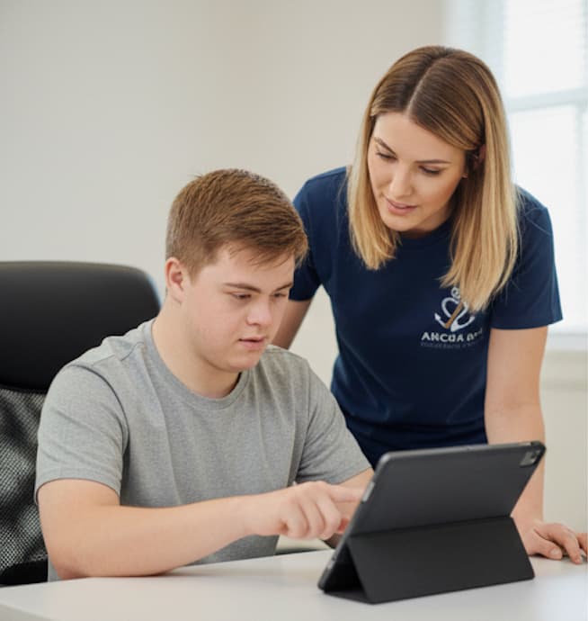 Support worker helping a young man with learning at home